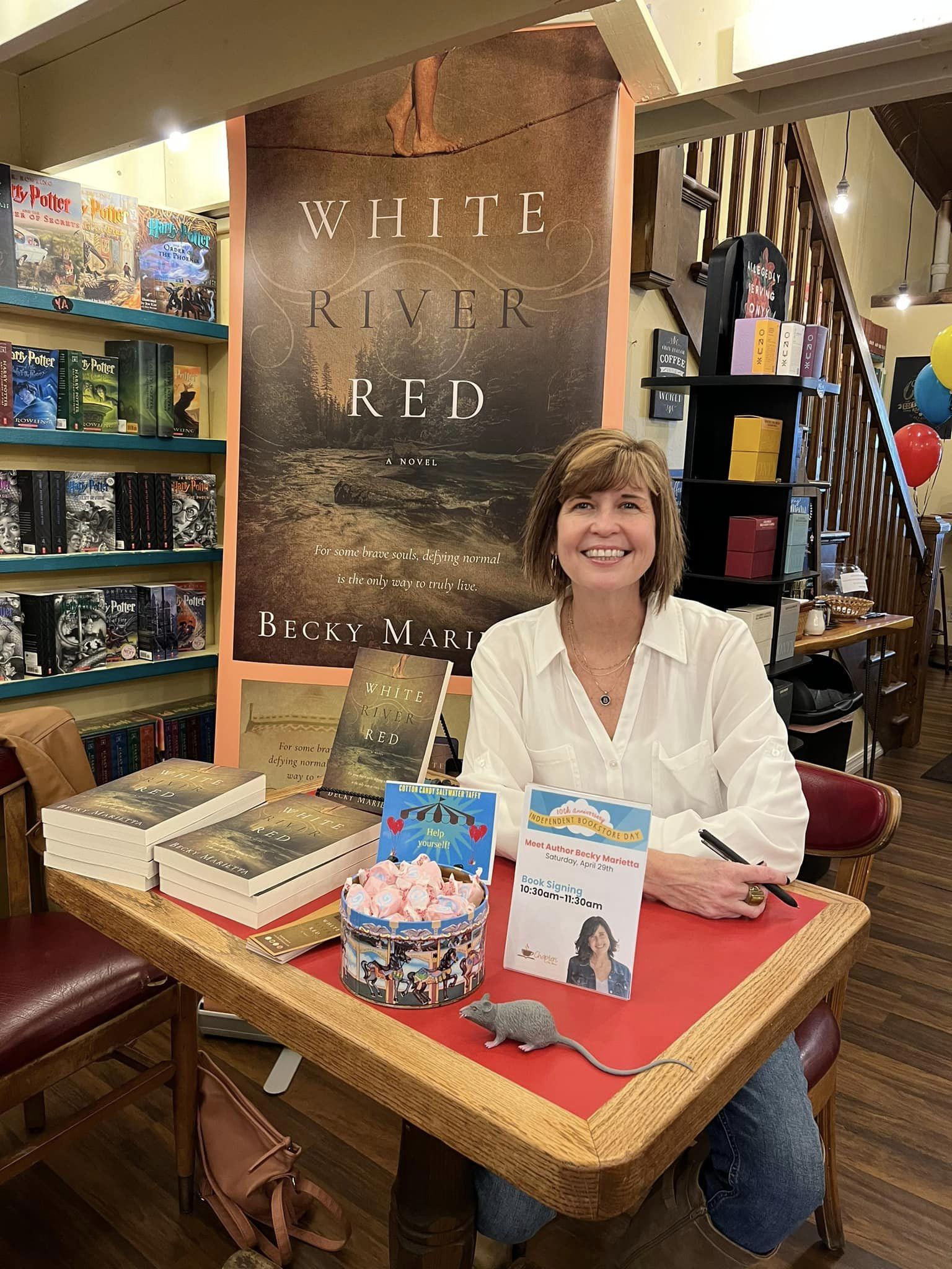 Woman in white shirt in front of book cover