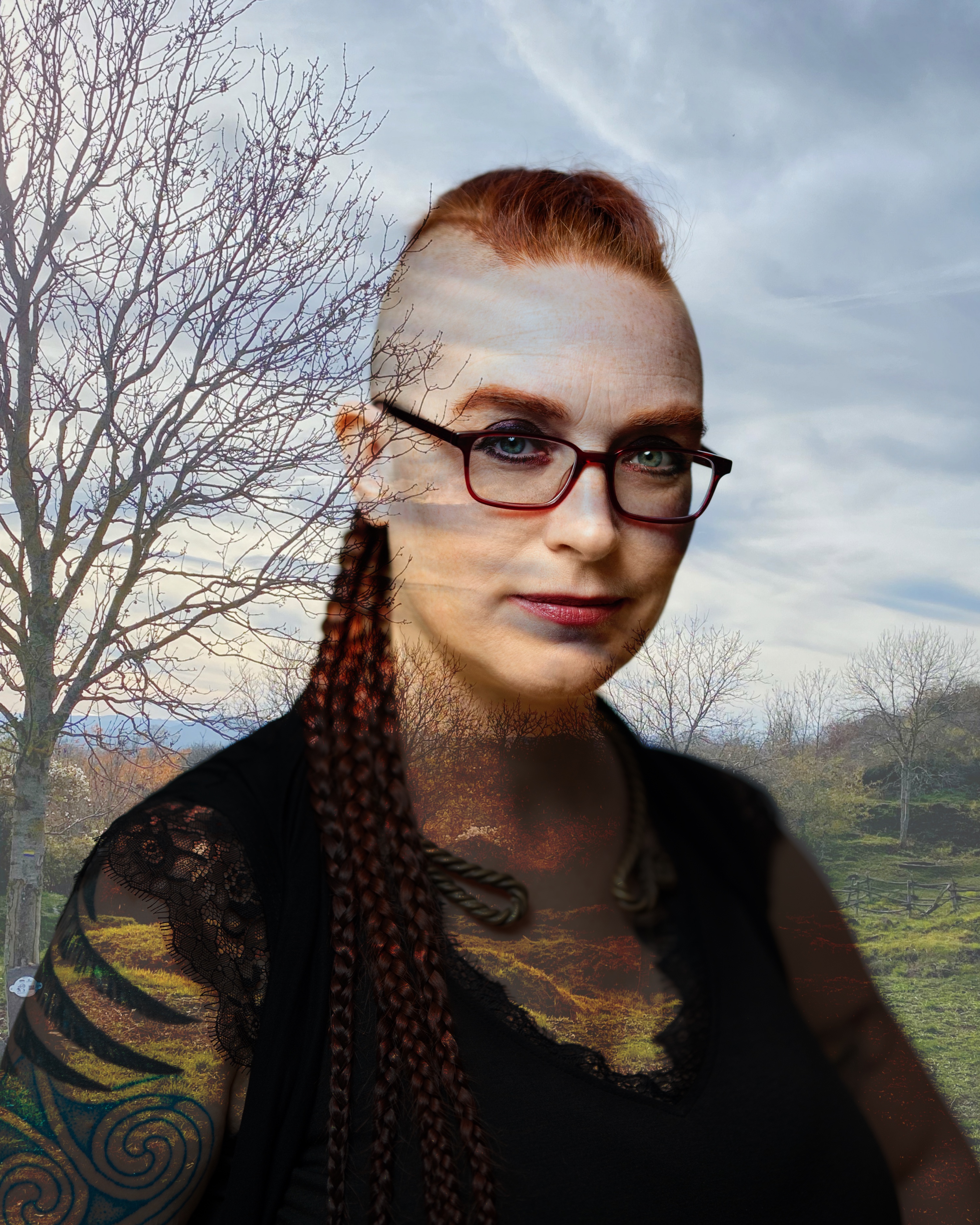 Femme presenting person with glasses, light skin, red hair shaved on the sides and braided, with an overlay showing a mountain landscape