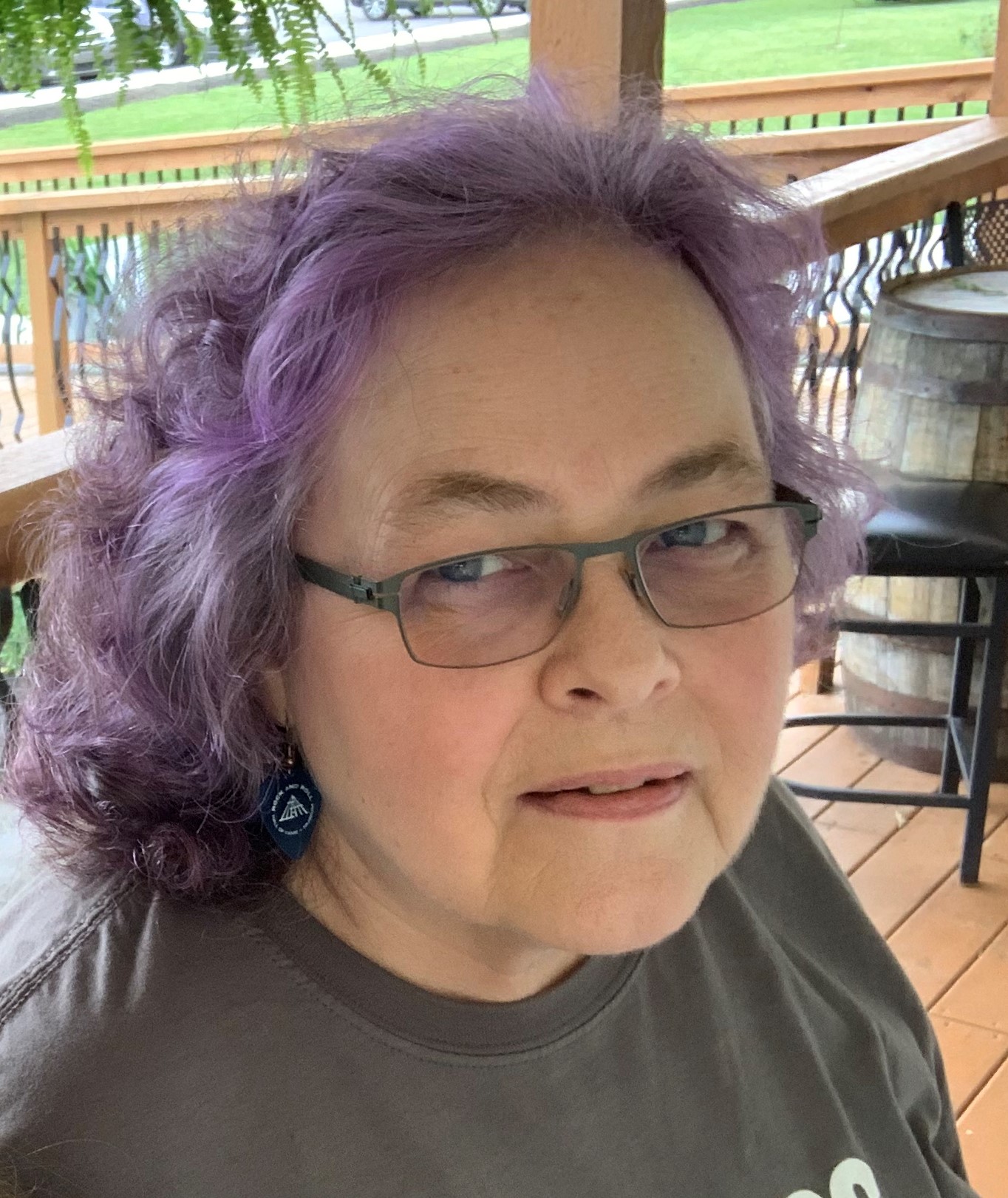 white woman with glasses and shoulder length hair that's dyed purple