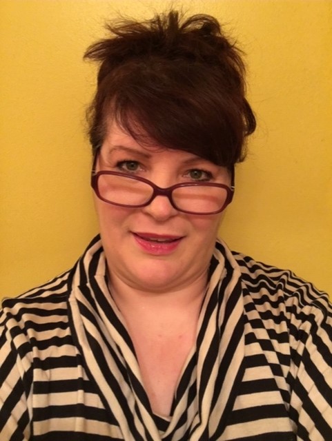 A woman with glasses wearing a striped black and white top