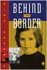 Cover of "Behind the Border" by Nina Kossman: a photo of the author as a first-grader in the Soviet union, in a  school uniform required of all Soviet students. An insert photo shows children in a Soviet kindergarten singing under a portrait of Lenin.  . 